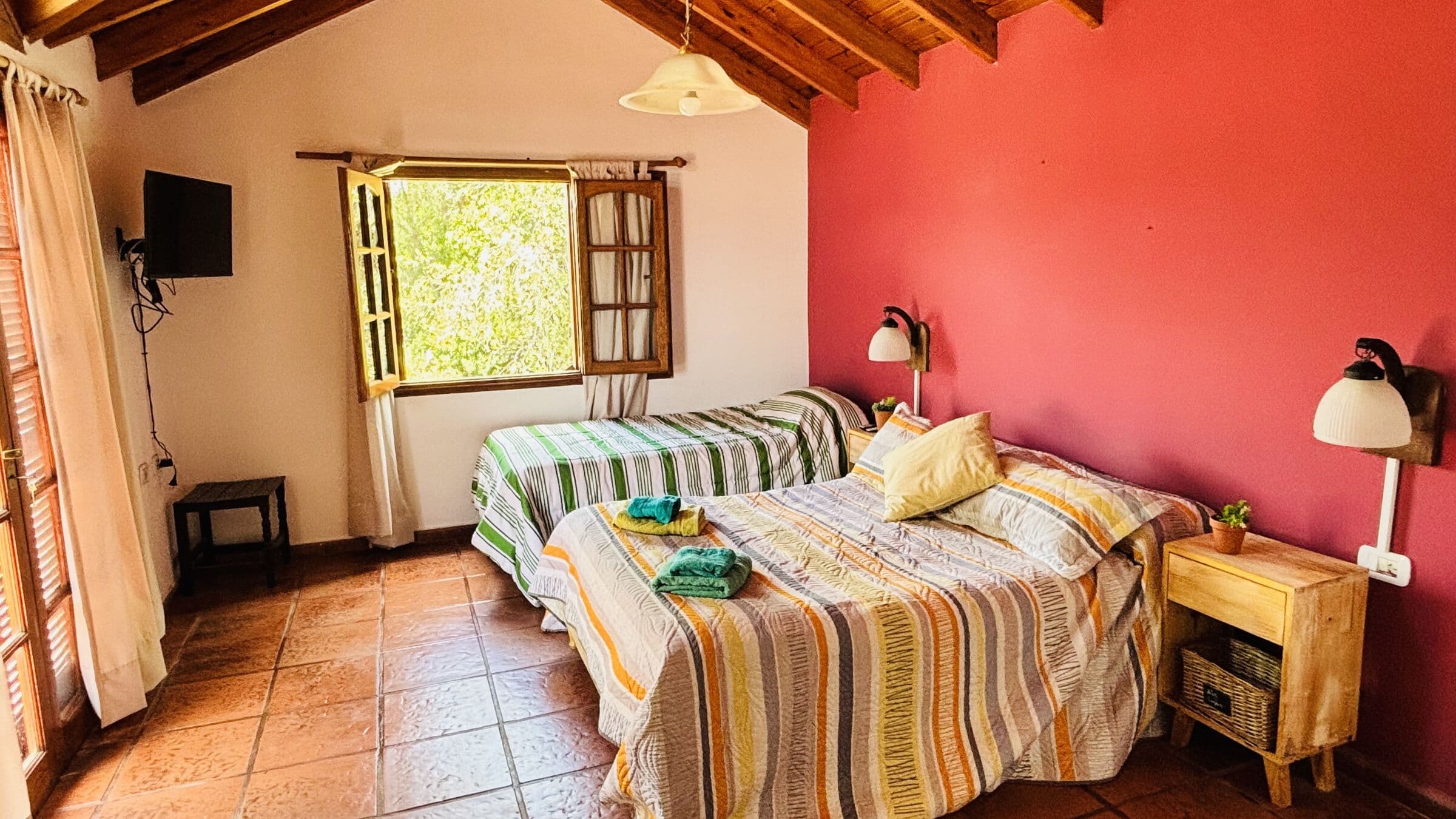 Dormitorio rojo con cama matrimonial y cama individual